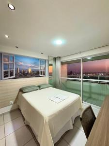 a bedroom with a bed and a view of a city at West Flat - BarretoStays 03 in Mossoró +10 photos