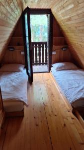 two beds in a room with a window at Apartma Jurjovka in Nazarje