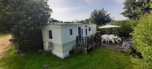 a tiny house in a yard with a table at Mobil-Home location in Plougrescant