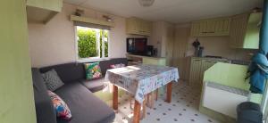 a small living room with a couch and a table at Mobil-Home location in Plougrescant