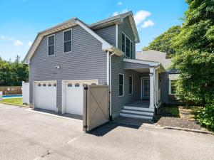 a gray house with a garage and a driveway at Beautiful 6-Bedroom Escape Featuring a Private Pool in Hampton Bays