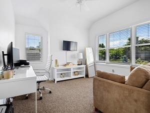 a living room with a couch and a desk and two windows at Beautiful 6-Bedroom Escape Featuring a Private Pool in Hampton Bays