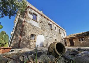 a building with a barrel in front of it at B e B- Il casale del melograno-Country House in Piano di Santa Laura
