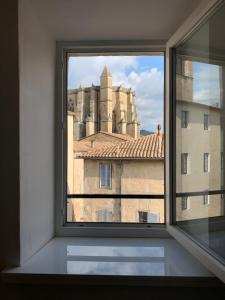 a window with a view of a building at Le bleu des toits in Lodève