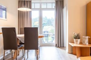 a dining room with a table and chairs and a window at Haus Roland, Wohnung 19 in Zinnowitz