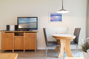 a living room with a desk with a tv and a table at Haus Roland, Wohnung 19 in Zinnowitz