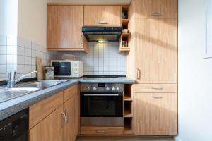 a kitchen with wooden cabinets and a stove top oven at Haus Roland, Wohnung 19 in Zinnowitz +15 photos