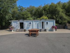 a blue caravan with a table in front of it at Meadows Farm Lodge in Swansea