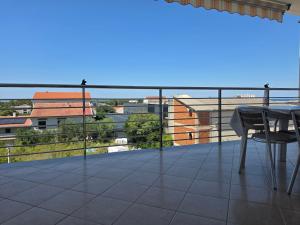 a balcony with a table and chairs on a building at Apartment Keti - Mandre in Mandre