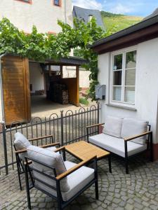 a patio with two chairs and a table and a bench at Zur Klapperburg in Zell an der Mosel