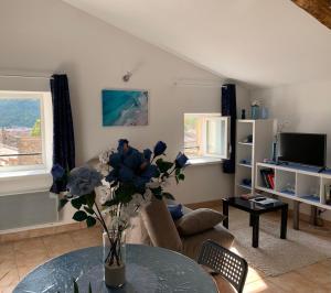 a living room with a vase of flowers on a table at Le bleu des toits in Lodève