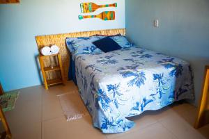 a bedroom with a bed with a blue and white comforter at Loft Azul - Pousada Vila Dondom in Luis Correia +13 photos