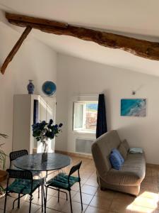 a living room with a table and a couch at Le bleu des toits in Lodève