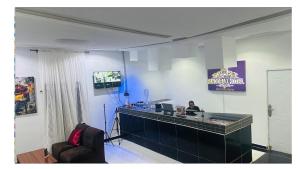 a woman sitting at a reception desk in a room at Pandorax Hotel and Lounge in Benin City