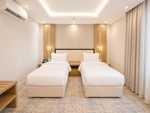 a hotel room with two beds and a table at Jwana in Riyadh