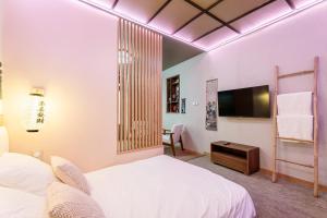 a hotel room with two beds and a tv at Le Bain de Sakura - Hypercentre in Marseille