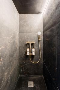 a bathroom with a shower with a black marble wall at Le Bain de Sakura - Hypercentre in Marseille