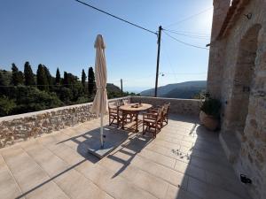 a patio with an umbrella and a table and chairs at Melias Olive Retreat in Kelefá