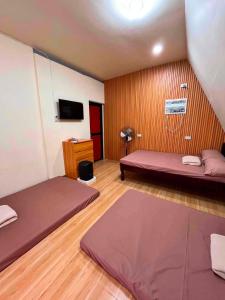 a room with two beds and a tv in it at Leonaldo's Farm and Staycation in Kinalaglagan