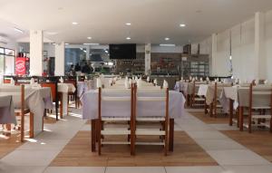 a dining room with white tables and chairs at Valbom by Campigir in Sesimbra