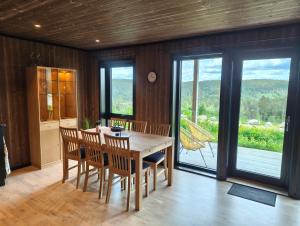 a dining room with a table and chairs and a window at Eikerapen Panorama in Åseral