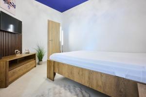 a bedroom with a large bed and a flat screen tv at Hotel Wellness Radnice Dobrovice in Dobrovice