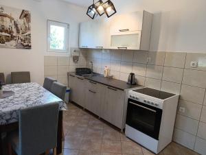 a kitchen with a table and a stove top oven at Green Valley GV in Kotor +10 photos