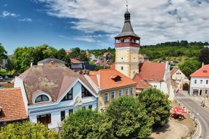 an old town with a clock tower on a hill at Hotel Wellness Radnice Dobrovice in Dobrovice