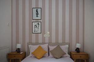 a bedroom with a bed with two nightstands and two lamps at La Nonna in Komotini