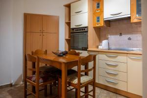 a small kitchen with a wooden table and chairs at La Nonna in Komotini