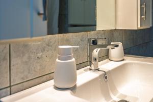 a bathroom sink with a soap dispenser on it at La Nonna in Komotini +15 photos