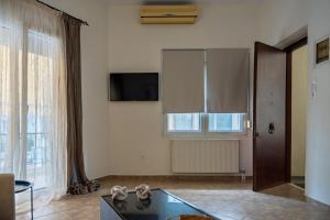 a living room with a glass table and a large window at La Nonna in Komotini