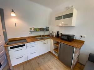 a small kitchen with white cabinets and a sink at Bavaria One in Cincu