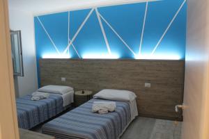 two beds in a room with blue lights at APPARTAMENTO TORRESI 2 in Ancona