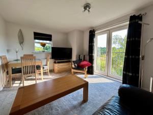 a living room with a couch and a table and a television at Light & Airy flat, Amazing view in Whitefield