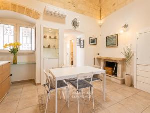 a kitchen and dining room with a white table and chairs at Wanderlust Experience Fronte Porto in Bari