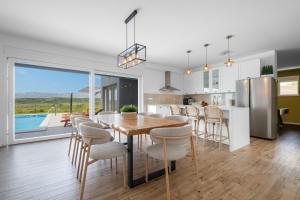 a kitchen and dining room with a table and chairs at Vila Matak in Ražanac