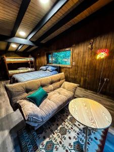 a room with a couch and a bed and a table at Cabañas Mountain Fox in Puerto Varas