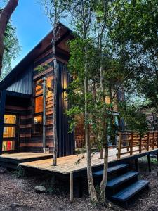 a cabin in the woods with a wooden deck at Cabañas Mountain Fox in Puerto Varas