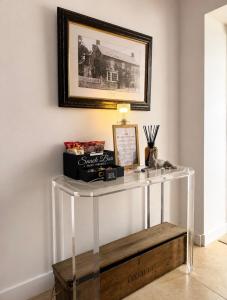 a white console table in a room with a picture at The Old Pub Wiltshire A Unique Luxury Cellar Retreat with Private Sauna Gym and Movie Room in Patney