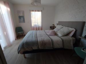 a bedroom with a bed in a room with a window at Chambre Terre et Mer-Millet in Gréville-Hague