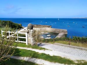 a stone wall with a gate and the ocean at Chambre Terre et Mer-Millet in Gréville-Hague +6 photos