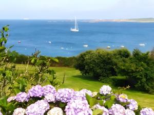 a view of the ocean with a boat in the water at Chambre Terre et Mer-Millet in Gréville-Hague