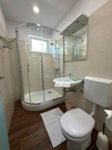 a bathroom with a shower and a toilet and a sink at Brela S1 S4-no parking in Brela