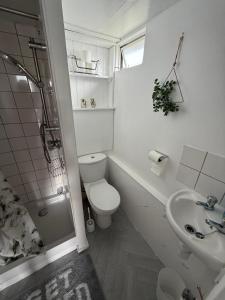 a white bathroom with a toilet and a sink at The View in Leysdown-on-Sea