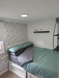 a bedroom with a bed with green sheets and pillows at The View in Leysdown-on-Sea
