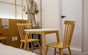a table and two chairs sitting next to a bed at Ryokan Hotel The Red Dragonfly in Incheon