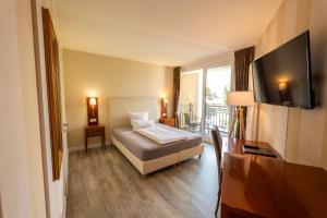 a hotel room with a bed and a television at Weinquartier Burggarten in Bad Neuenahr-Ahrweiler