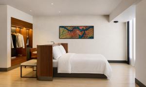 a bedroom with a bed and a chair in it at Cambria Hotel Jacksonville in Jacksonville