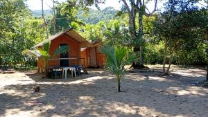 a small wooden cabin with a table in front of it at FOLHA HOUSE Experience in Paraty
